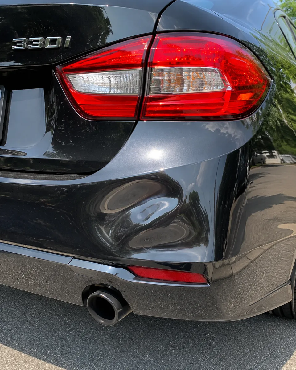 BMW 330i rear bumper dent repaired, original finish preserved in Apache Junction, AZ, before