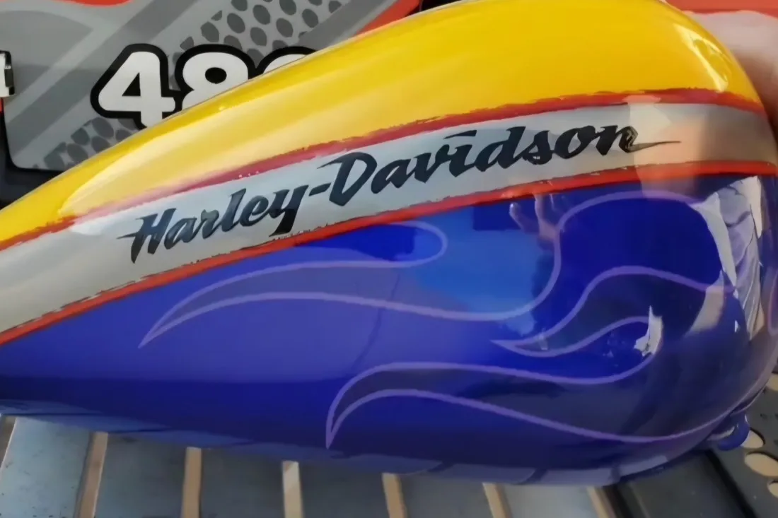 Custom flame Harley-Davidson fuel tank dent repaired with PDR, blue flame paint preserved in Apache Junction, AZ, after